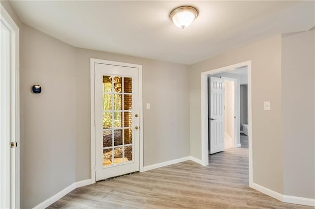 doorway to outside featuring light wood finished floors and baseboards