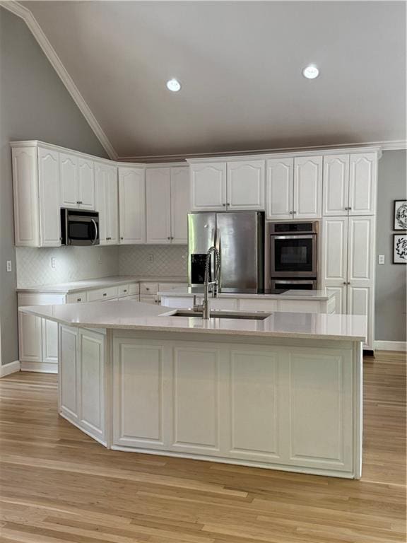kitchen with lofted ceiling, white cabinetry, tasteful backsplash, and stainless steel appliances