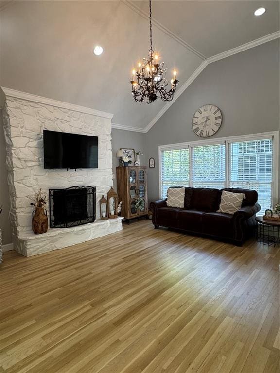 living room featuring an inviting chandelier, wood finished floors, ornamental molding, a fireplace, and high vaulted ceiling