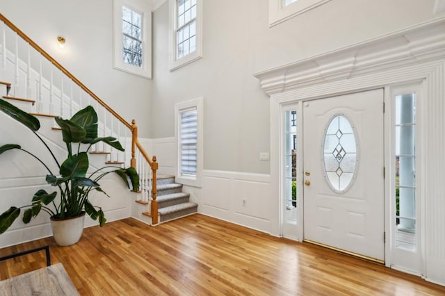 foyer entrance with light hardwood / wood-style flooring and a high ceiling