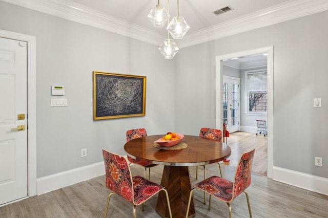 dining room with crown molding and hardwood / wood-style floors