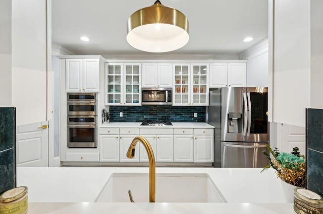 kitchen featuring tasteful backsplash, appliances with stainless steel finishes, sink, and white cabinets