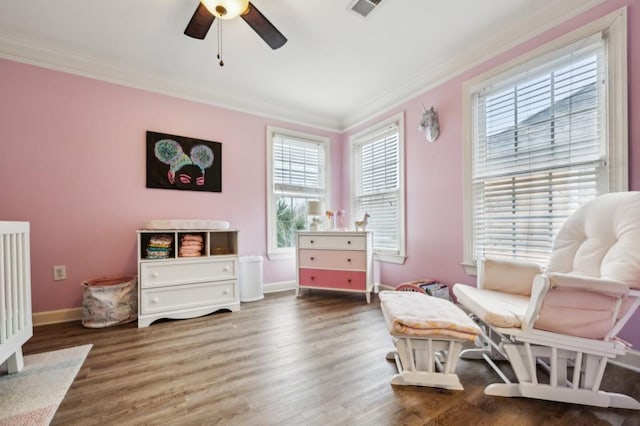 living area with crown molding, ceiling fan, and dark hardwood / wood-style flooring