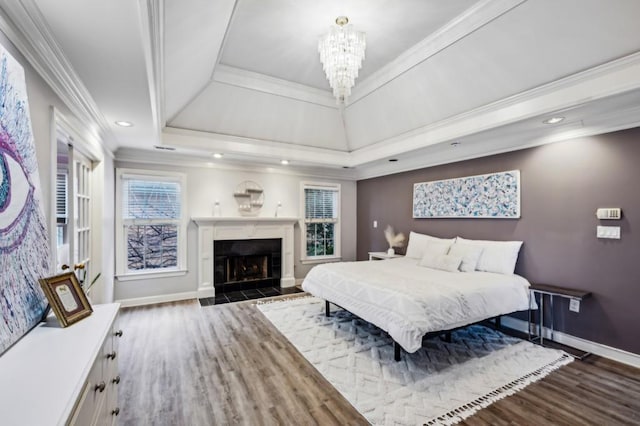 bedroom featuring crown molding, dark wood-type flooring, a chandelier, and a tray ceiling