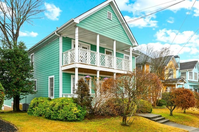 view of front of home with a front yard and a balcony