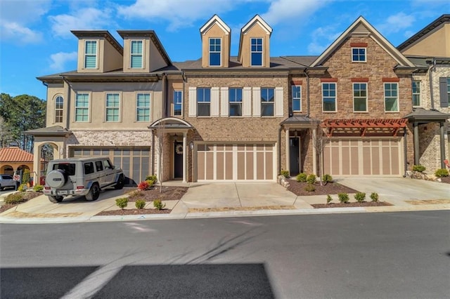 multi unit property with driveway, a garage, and brick siding