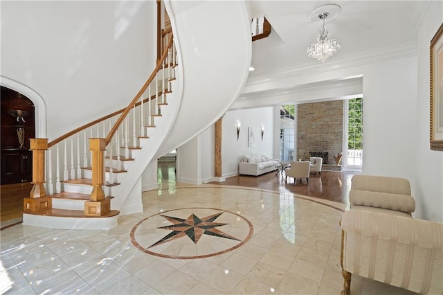 4340 Candacraig, Johns Creek, GA 30022 - entryway with stairs, ornamental molding, a fireplace, a chandelier, and baseboards