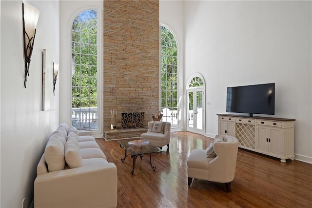 4340 Candacraig, Johns Creek, GA 30022 - living room with wood finished floors, a towering ceiling, a stone fireplace, and baseboards