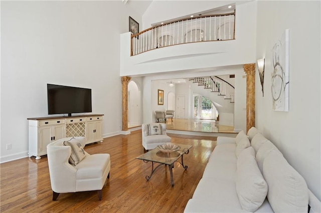 4340 Candacraig, Johns Creek, GA 30022 - living area featuring stairway, arched walkways, wood finished floors, a high ceiling, and baseboards