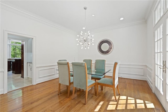 4340 Candacraig, Johns Creek, GA 30022 - dining room featuring crown molding, light wood-style flooring, a chandelier, a decorative wall, and a wainscoted wall