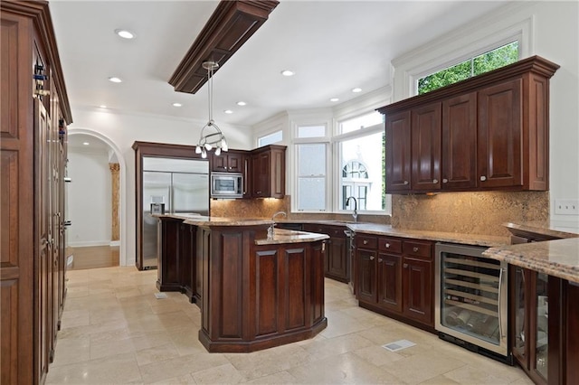 4340 Candacraig, Johns Creek, GA 30022 - kitchen featuring beverage cooler, built in appliances, light stone countertops, backsplash, and a sink
