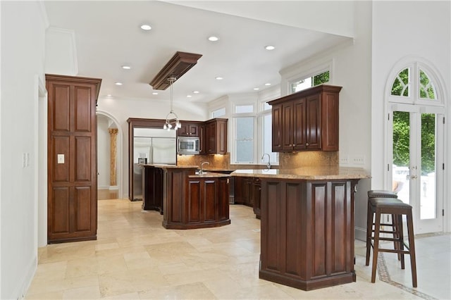 4340 Candacraig, Johns Creek, GA 30022 - kitchen featuring built in appliances, a peninsula, decorative backsplash, a breakfast bar, and recessed lighting