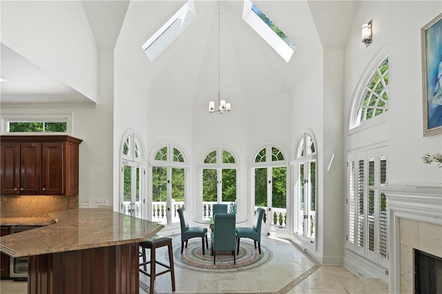 4340 Candacraig, Johns Creek, GA 30022 - dining space with high vaulted ceiling, inlaid floor details, a skylight, a tile fireplace, and baseboards