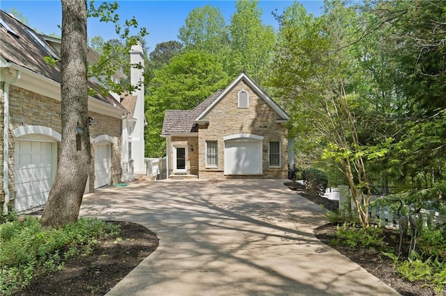 4340 Candacraig, Johns Creek, GA 30022 - view of front of house with concrete driveway, stone siding, and a chimney
