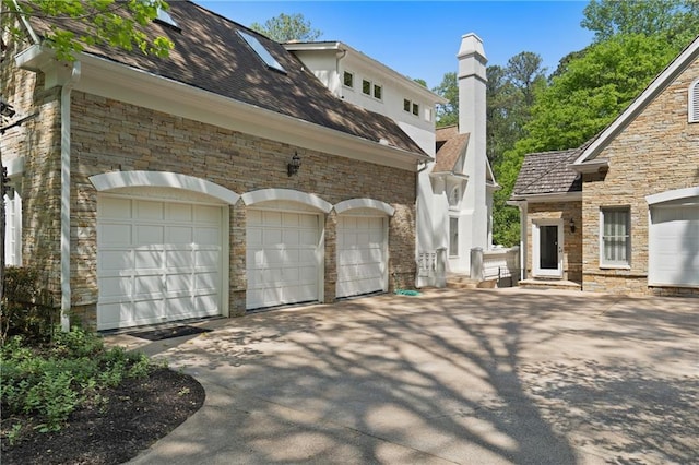 4340 Candacraig, Johns Creek, GA 30022 - view of property exterior with stone siding, concrete driveway, a garage, and a chimney