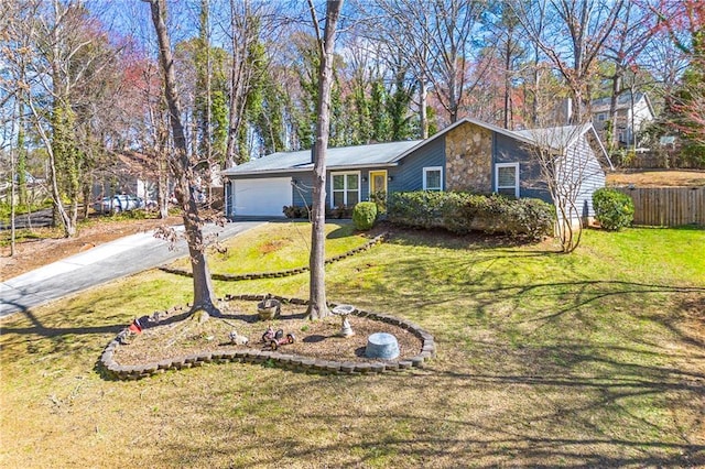 view of front of home featuring aphalt driveway, a garage, fence, stone siding, and a front yard