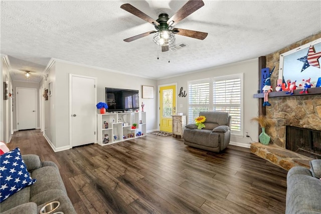 living room featuring a textured ceiling, ornamental molding, wood finished floors, and visible vents