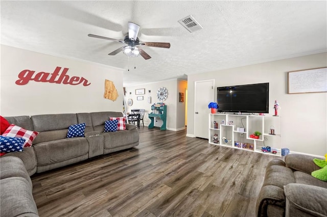 living room with a textured ceiling, wood finished floors, visible vents, baseboards, and a ceiling fan