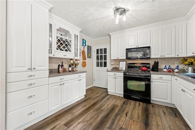 kitchen with dark wood-style flooring, backsplash, glass insert cabinets, white cabinetry, and black appliances