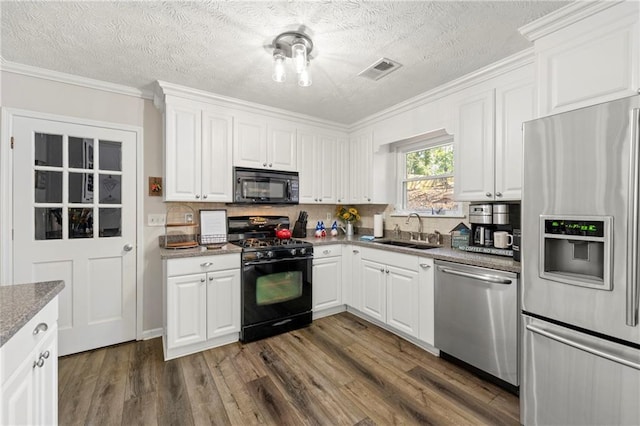 kitchen featuring visible vents, white cabinets, dark wood-type flooring, black appliances, and a sink