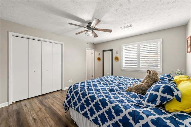 bedroom with visible vents, a ceiling fan, wood finished floors, a textured ceiling, and a closet