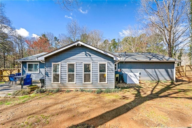 rear view of house with fence and a patio