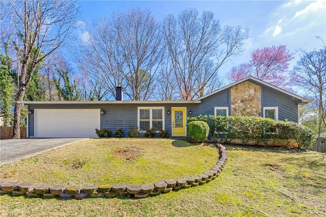 view of front of home with stone siding, a front lawn, an attached garage, and driveway