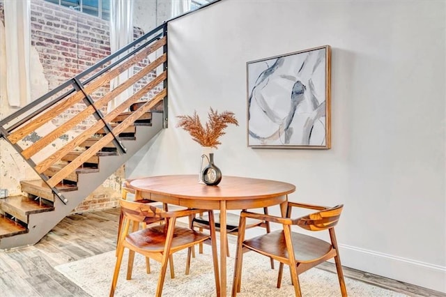 dining room featuring stairs, baseboards, and wood finished floors