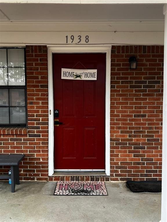 view of exterior entry with brick siding