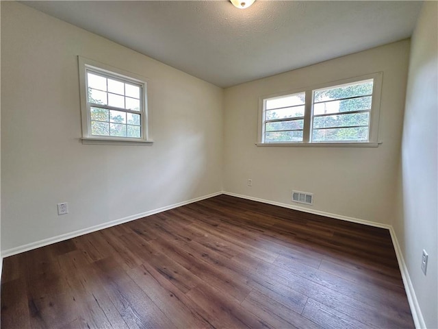 empty room featuring dark hardwood / wood-style flooring