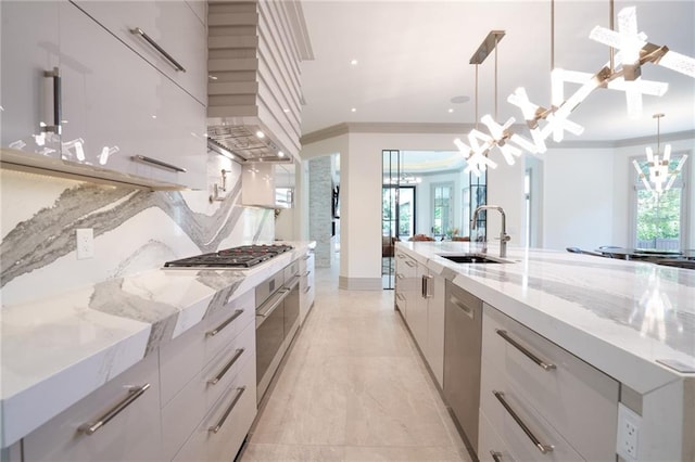 kitchen featuring sink, hanging light fixtures, a large island with sink, and stainless steel appliances