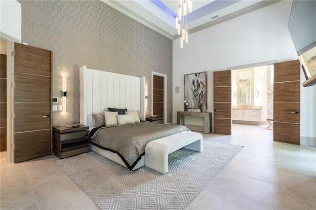 bedroom featuring light tile patterned flooring, a towering ceiling, ornamental molding, and connected bathroom