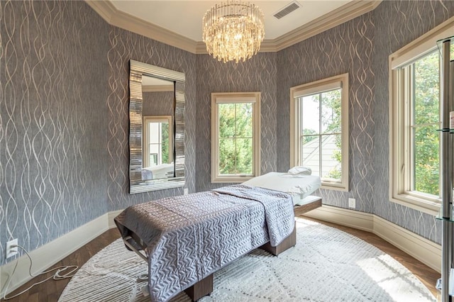 bedroom with an inviting chandelier, ornamental molding, and hardwood / wood-style flooring