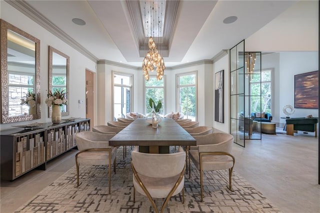 dining area with a raised ceiling, crown molding, and an inviting chandelier