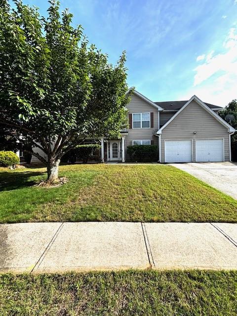 7178 Glaspie Way, Atlanta, GA 30349 - view of front of house featuring a front lawn, an attached garage, concrete driveway, and french doors