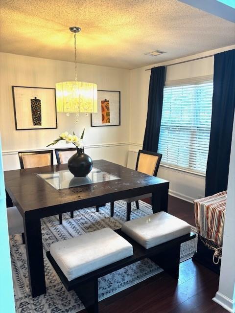 7178 Glaspie Way, Atlanta, GA 30349 - dining room featuring dark wood finished floors, a textured ceiling, and a chandelier