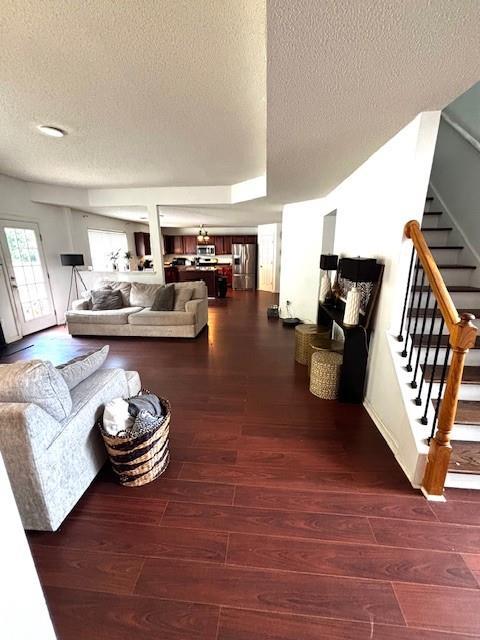 7178 Glaspie Way, Atlanta, GA 30349 - living room with a textured ceiling, stairway, and wood finished floors