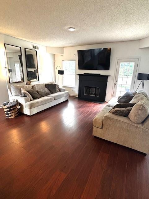 7178 Glaspie Way, Atlanta, GA 30349 - living room with a textured ceiling, a fireplace, and dark wood-style floors