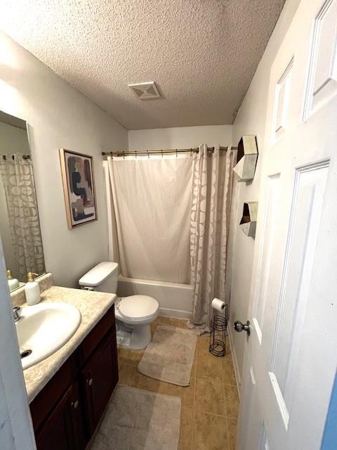 7178 Glaspie Way, Atlanta, GA 30349 - bathroom featuring vanity, a textured ceiling, tile patterned flooring, and shower / tub combo with curtain