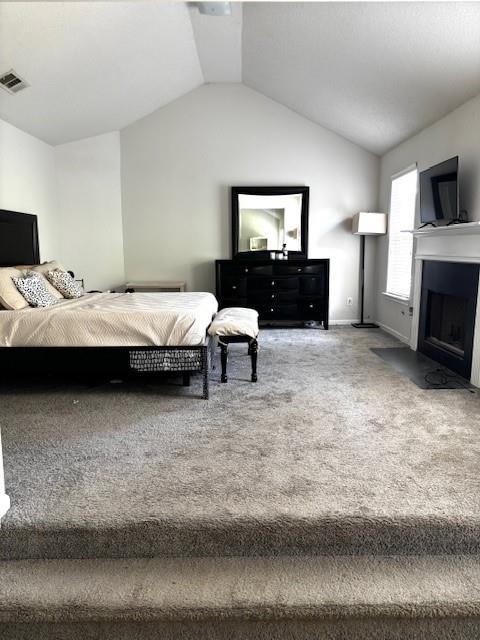 7178 Glaspie Way, Atlanta, GA 30349 - carpeted bedroom featuring vaulted ceiling and a fireplace with flush hearth