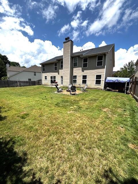 7178 Glaspie Way, Atlanta, GA 30349 - rear view of house featuring a chimney and a fire pit