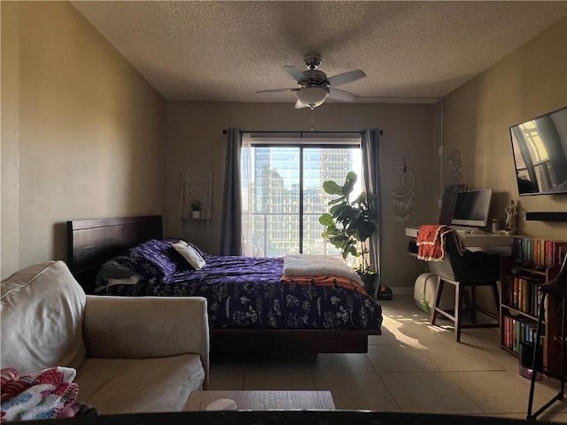 bedroom with a textured ceiling, ceiling fan, and light tile patterned flooring