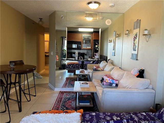 tiled living room featuring a textured ceiling