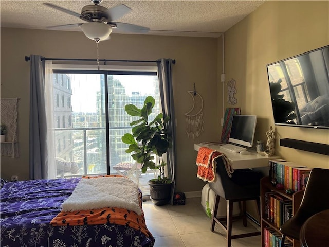 bedroom featuring ceiling fan, light tile patterned floors, and a textured ceiling