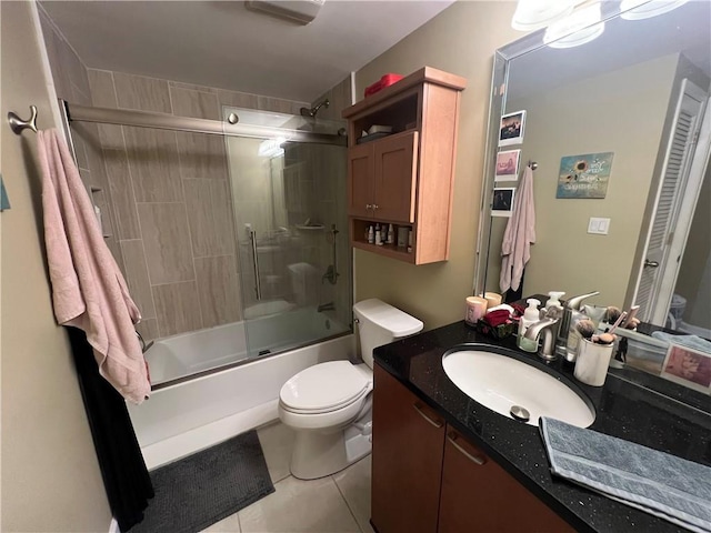 full bathroom featuring tile patterned flooring, vanity, toilet, and combined bath / shower with glass door