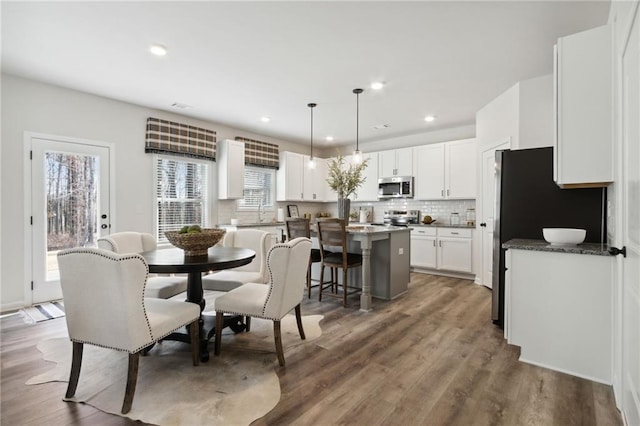 dining space with light wood-type flooring and recessed lighting