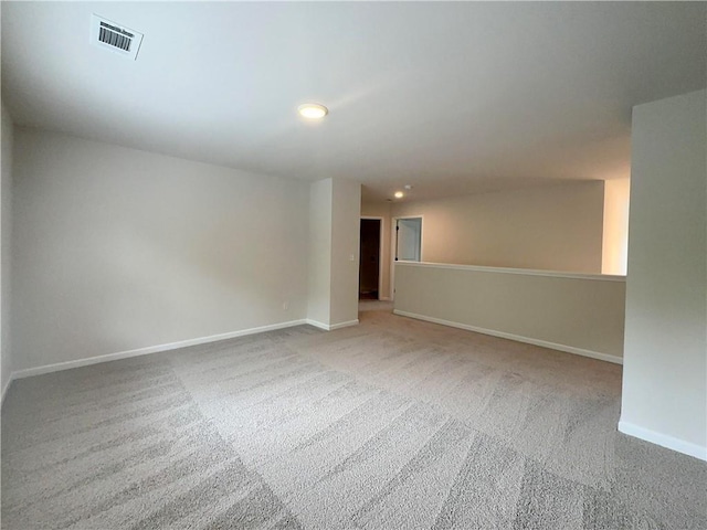 carpeted empty room featuring visible vents and baseboards