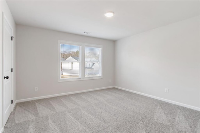 carpeted spare room featuring baseboards and visible vents