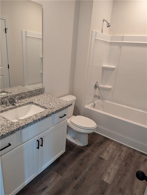 bathroom featuring toilet, shower / bathtub combination, wood finished floors, and vanity