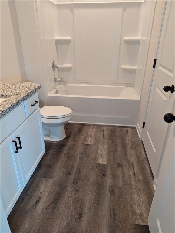 full bathroom featuring shower / washtub combination, vanity, toilet, and wood finished floors